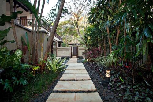 a garden path with trees and a building at Sundara Oceanside Villa in Tanah Lot