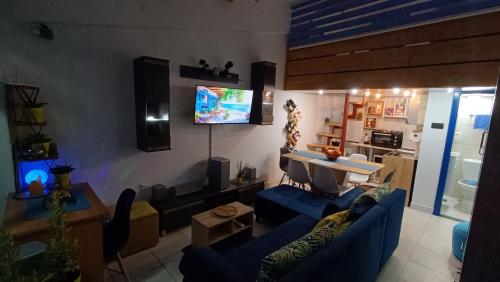 a living room with a blue couch and a tv at Nitro Inn 1 Premium Cozy - Wine Tasting - Souvenir - Art Gallery - Private Guided Tours - Relaxing - Romantic in Skopje