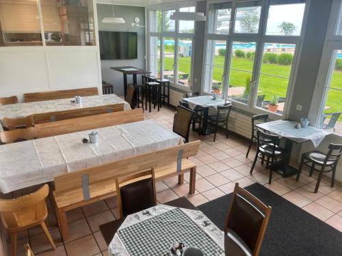 um restaurante com mesas, cadeiras e janelas em Herberge-Unterkunft-Seeperle in Rorschach em Rorschach