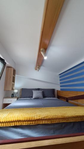 a bedroom with a bed with blue and yellow sheets at Nitro Inn 1 Premium Cozy - Wine Tasting - Souvenir - Art Gallery - Private Guided Tours - Relaxing - Romantic in Skopje