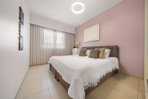 a bedroom with a large bed with white sheets and pillows at Isrentals Haneviim - ApartHotel In City Center in Jerusalem