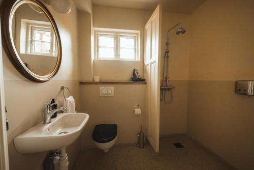 a bathroom with a sink and a mirror and a toilet at Wilderness Center / Óbyggðasetur Íslands in Óbyggðasetur