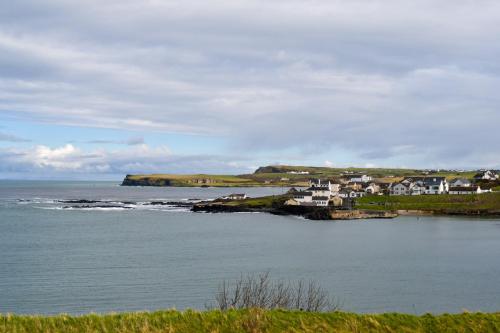 a group of houses on an island in the water at Shoreline Portballintrae North Coast Views Near Giants Causeway & Royal Portrush in Portballintrae