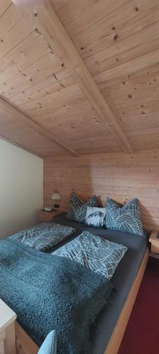 two beds in a room with a wooden ceiling at Maurerhof Itter in Itter