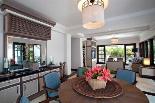 a dining room with a table with a vase of flowers on it at Sundara Oceanside Villa in Tanah Lot