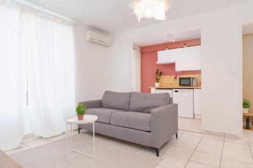 een woonkamer met een bank en een tafel bij Le Gabin By ApiRent #Centre-ville #Climatisation #Wifi in Cannes