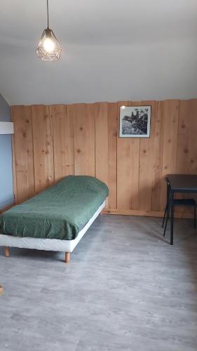 sypialnia z łóżkiem i stołem w obiekcie Les Grands Riez - logement à la campagne 