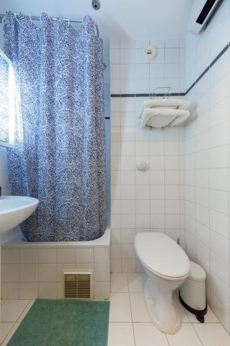a bathroom with a toilet and a shower and a sink at ADAGIO Access - PARIS LA DEFENSE in Courbevoie