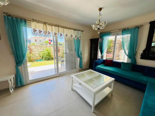 a living room with a blue couch and a table at Evalacati - Villa Palma-Tamamen Müstakil Villa in Cesme