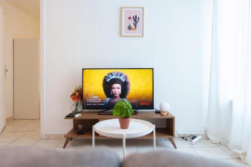 een woonkamer met een tv en een tafel bij Le Gabin By ApiRent #Centre-ville #Climatisation #Wifi in Cannes