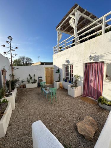 Un patio con sillas y una mesa frente a un edificio. en Villa Mi Marino, en Fernán Pérez