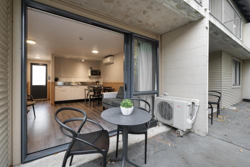 a patio with a table and chairs and a kitchen at Tasman Holiday Parks - Christchurch in Christchurch