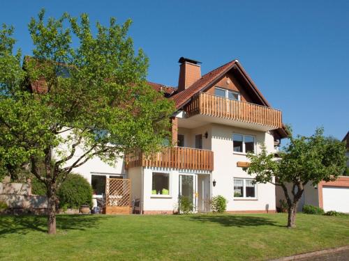 uma grande casa branca com árvores no quintal em Komfortable Ferienwohnung mit Seeblick - b56594 em Bad Arolsen