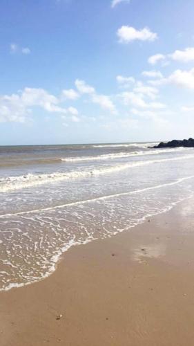a sandy beach with waves on the ocean at 2 Storey 3 Bedroom Chalet -Outdoor Swimming Pool - sleeps up to 6 - 5 min walk to the Beach, near Broads and Great Yarmouth in Scratby