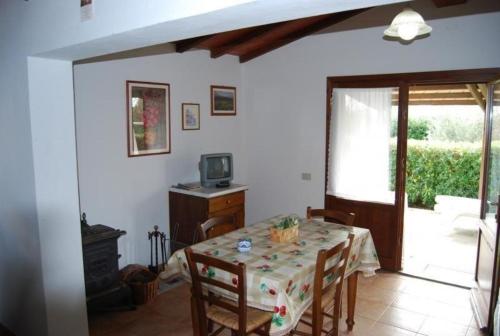 ein Esszimmer mit einem Tisch und einem TV in der Unterkunft Ferienhaus in Cecina mit Großem Garten in Cecina