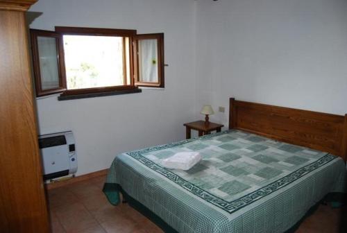ein Schlafzimmer mit einem Bett mit einer karierten Bettdecke in der Unterkunft Ferienhaus in Cecina mit Großem Garten in Cecina