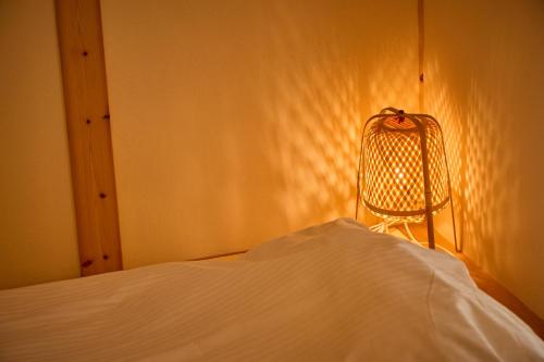 a bedroom with a bed and a chair in the corner at Villa 天ツ星 in Tahara