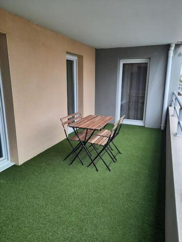 d'une table et de chaises sur un balcon avec de l'herbe verte dans l'établissement Appartement T2 climatisé avec terrasse, à Port-Saint-Louis-du-Rhône