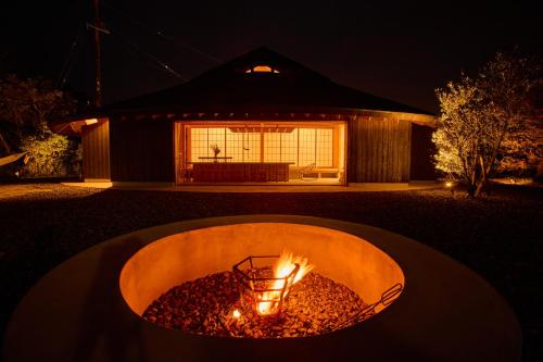 a fire pit in front of a house at night at Villa 天ツ星 in Tahara