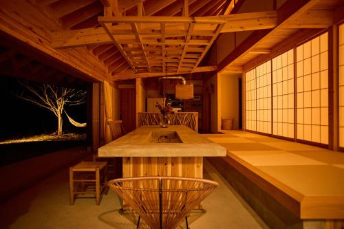 a kitchen with a counter and chairs in a room at Villa 天ツ星 in Tahara