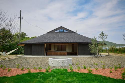 a small house with a black roof at Villa 天ツ星 in Tahara