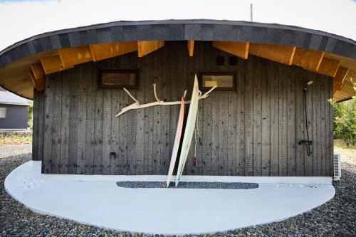 a wooden building with a clock in front of it at Villa 天ツ星 in Tahara