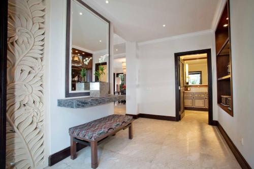 a hallway with a bench and a mirror on a wall at Sundara Oceanside Villa in Tanah Lot