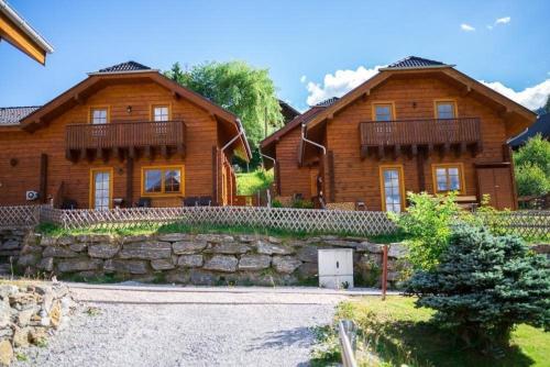 a large wooden house with a stone wall at Charmantes Ferienhaus in Sankt Margarethen Im Lungau mit Kleinem Garten und Bergblick in Sankt Margarethen im Lungau