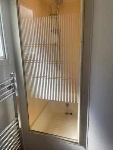 W łazience znajduje się prysznic ze szklanymi drzwiami. w obiekcie Caravan F8 Aberystwyth Holiday Village w Aberystwyth