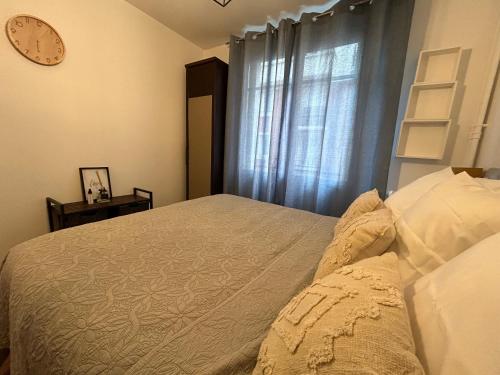 um quarto com uma cama e um relógio na parede em Appartement cosy, Bois de Vincennes-porte de Paris em Saint-Mandé