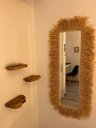 a mirror on a wall with a chair and a table at Le Maschere B&B in Santa Teresa Gallura