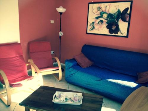 sala de estar con sofá azul y 2 sillas en Schönes Appartement in Tiarno Di Sotto mit Garten, en Tiarno di Sotto