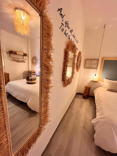 a mirror in a room with two beds at Le Maschere B&B in Santa Teresa Gallura