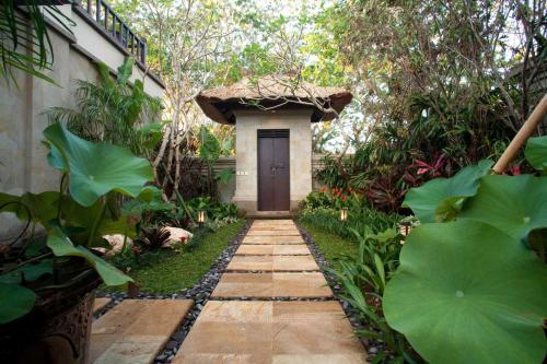 a walkway leading to a door in a garden at Sundara Oceanside Villa in Tanah Lot
