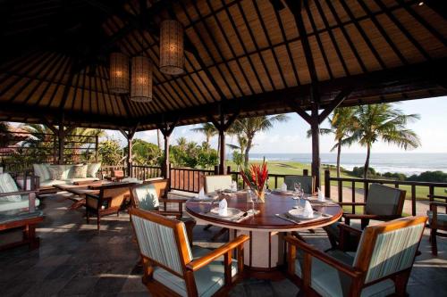 a restaurant with tables and chairs and a view of the ocean at Sundara Oceanside Villa in Tanah Lot