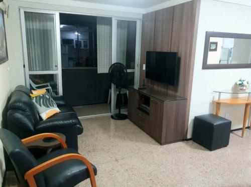 a living room with a couch and a television at Espaço para sentir-se bem. in Fortaleza