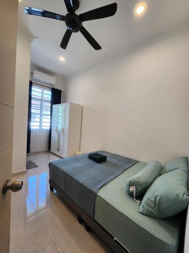a bedroom with a bed with a ceiling fan at (Female Only) Dungun Town CoLiving Homestay in Dungun