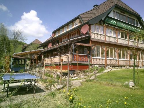 een groot huis met een picknicktafel ervoor bij Appartement in Innerlehen mit Terrasse, Grill und Garten in Bernau im Schwarzwald
