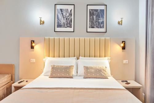 a bedroom with a large white bed with two pillows at Hotel Brooklyn - ex Hotel Lombardi in Florence