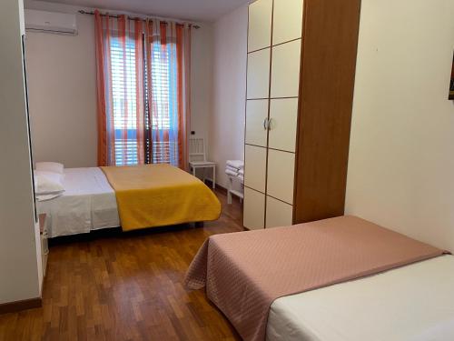 Habitación pequeña con 2 camas y ventana en Villa Alba en Fermo