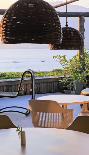 a view of the ocean from a restaurant with tables and chairs at Hotel Boutique Ananas in Ilhabela