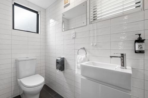 a white bathroom with a toilet and a sink at Tasman Holiday Parks - Christchurch in Christchurch