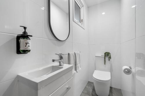 a white bathroom with a sink and a mirror at Tasman Holiday Parks - Christchurch in Christchurch