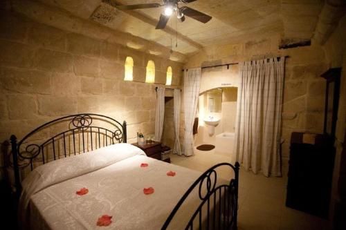 - une chambre avec un lit orné de roses dans l'établissement Villa Tina, à L-Għarb