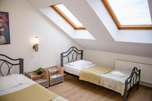 two beds in a attic room with skylights at Hotel Pas Katina in Panevėžys