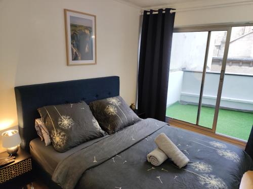 une chambre avec un lit et une grande fenêtre dans l'établissement Trocadéro suite Paris 16ieme - with balcony, à Paris