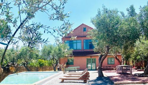 a house with a swimming pool in front of a building at Seaview and Olives Panorama Villa Joyanna in Mani in Kalívia