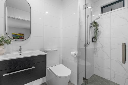 a white bathroom with a toilet and a shower at Tasman Holiday Parks - Christchurch in Christchurch