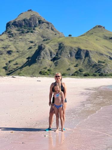 a man and a little girl standing on a beach at Jhuna Komodo Homestay in Komodo