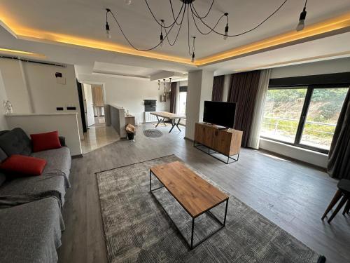 ein Wohnzimmer mit einem Sofa und einem Couchtisch in der Unterkunft YUNUSELİ 7+2 VİLLA LUXURY in Yunuseli